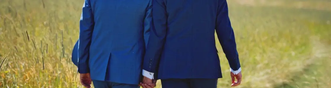 zwei Männer im Anzug halten Händchen
