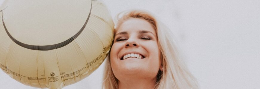 lächelnde Frau mit Smilie-Ballon