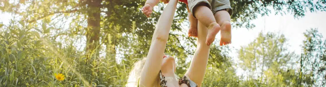 Mutter und Baby spielen im Grünen