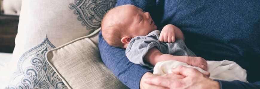 Erwachsener hält Neugeborenes im Arm
