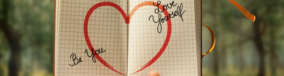 Notizbuch zeigt die Botschaften "Be You" und "Love Yourself"
