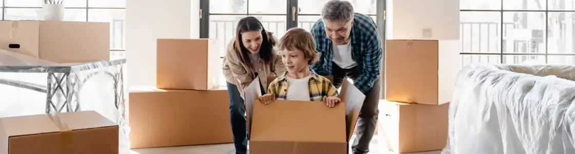 dreiköpfige Familie packt Kartons für Umzug